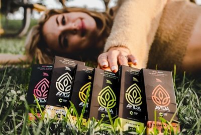 A person holding an AVIDA Puff disposable CBD vape pen, taking a puff with a focus on the pen's sleek design and smooth vapor.