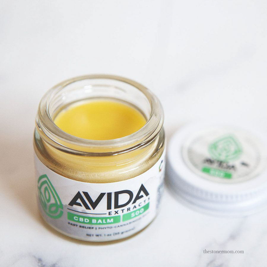 AVIDA Extracts 500mg CBD balm with the lid off, highlighting the smooth golden balm inside, crafted for fast-acting relief, shown against a clean white surface.