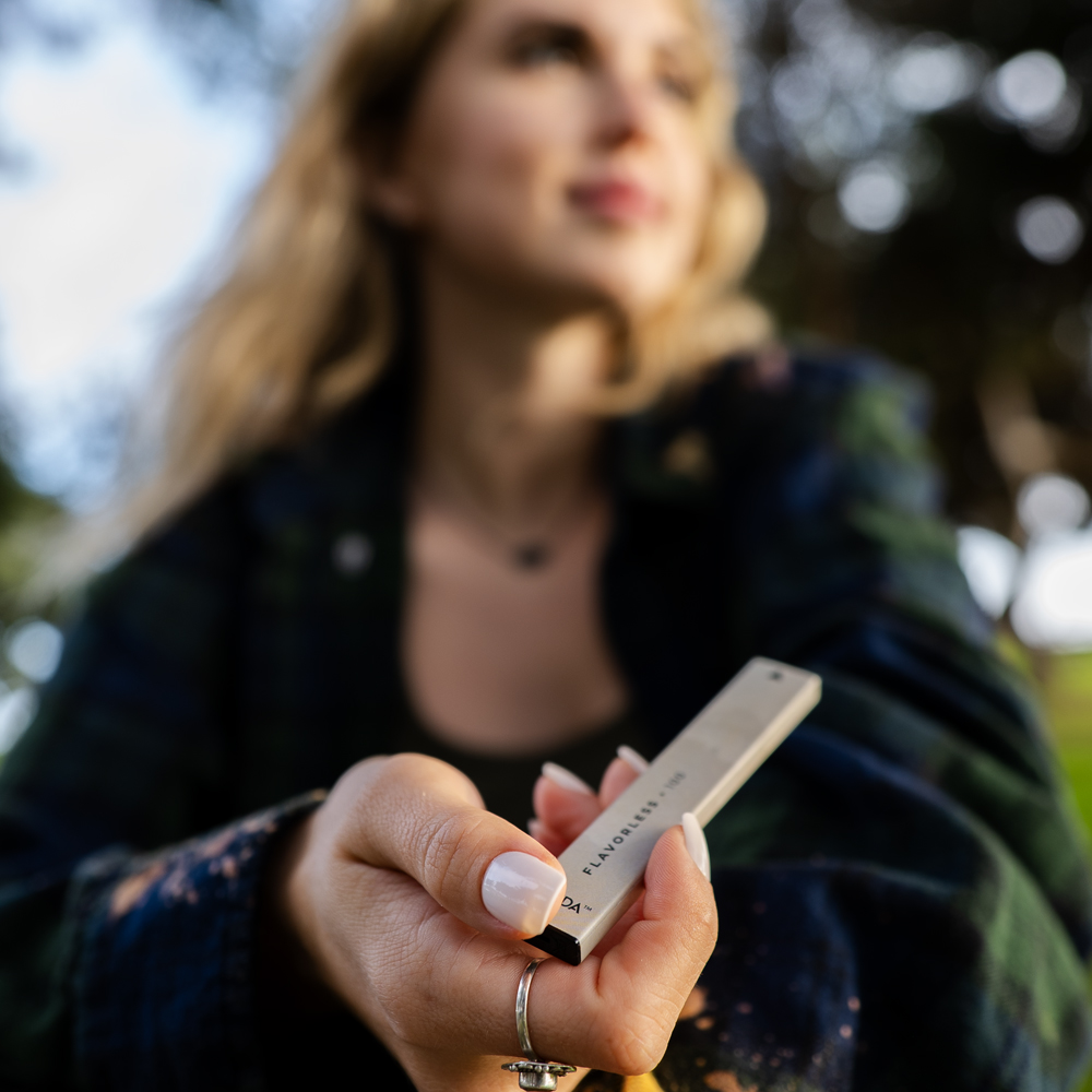 girl sitting at park vaping a CBD pen